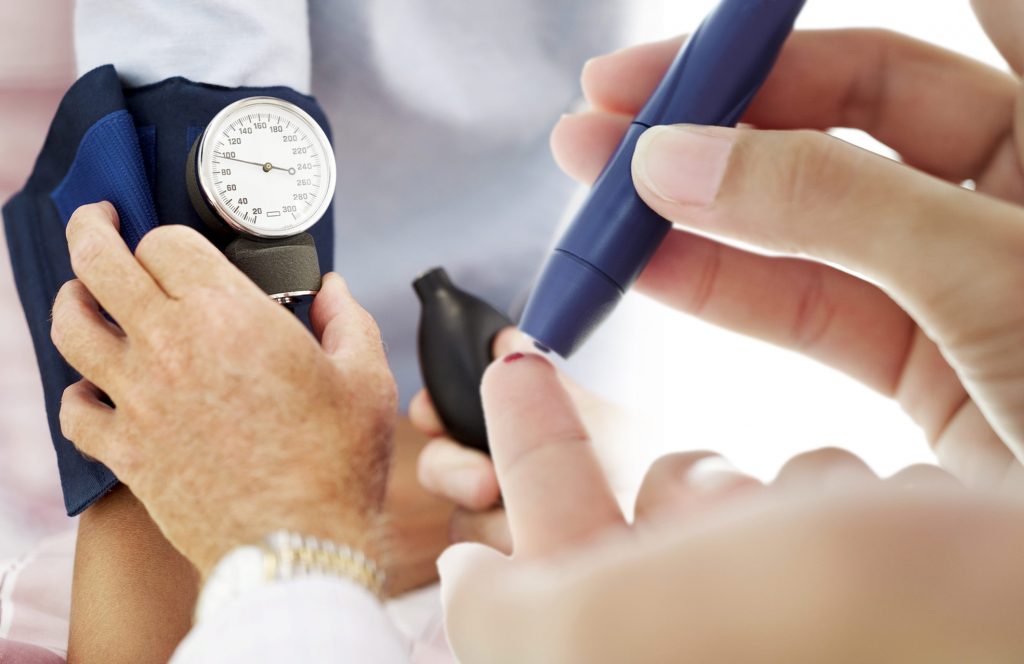 Pair of Human Hands Checking the Blood Pressure of a Patient --- Image by © Royalty-Free/Corbis